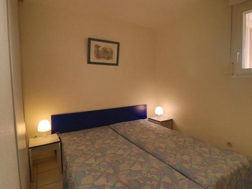 - une chambre avec un lit et deux lumières sur deux tables dans l'établissement Charmant 2 pièces avec terrasse, piscine et accès direct à la plage à Sète - FR-1-472A-304, à Sète