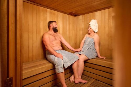 a man and a woman sitting in a sauna at Barrakee Ski Lodge in Perisher Valley
