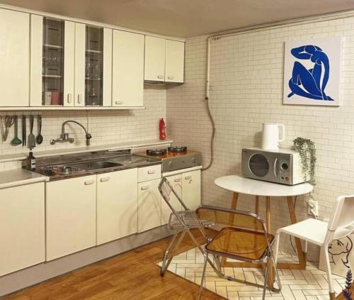 a kitchen with white cabinets and a table and a microwave at Boutique,seoul in Seoul