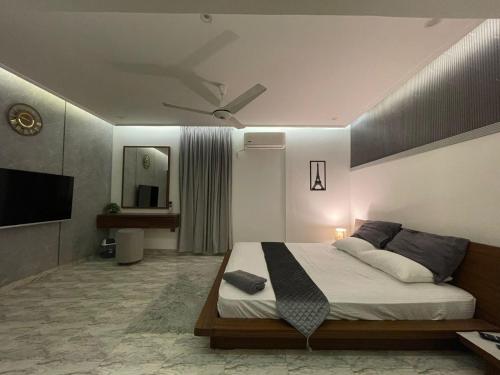 a bedroom with a bed with a ceiling fan at Luxury Living Penthouse Gulshan Iqbal Block#7 in Karachi