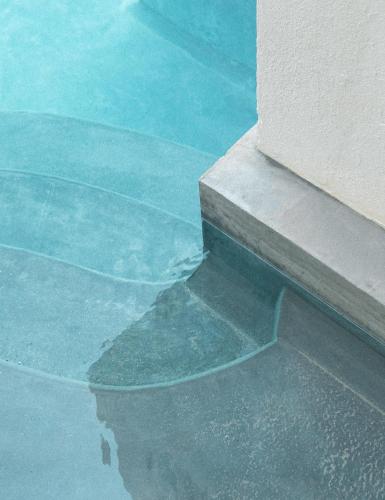 a pool of water next to a building at COCCOLOBA in Holbox Island