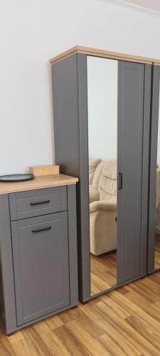 a desk with a mirror next to a table with a laptop at Central Stay in Tîrgu Neamţ