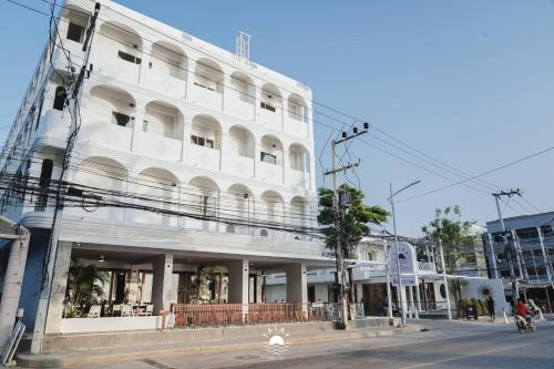a white building on the corner of a street at Talay Hotel and Villa Cha-am in Cha Am