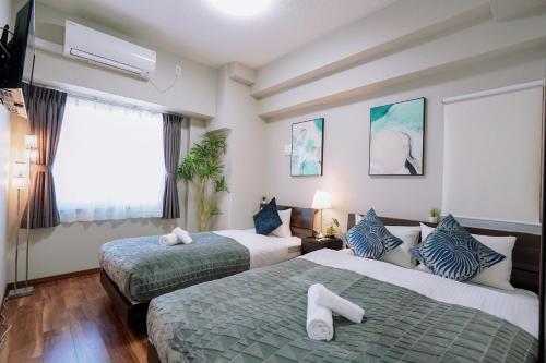 ein Hotelzimmer mit 2 Betten und einem TV in der Unterkunft Kuromon Royal Niponbashi in Osaka