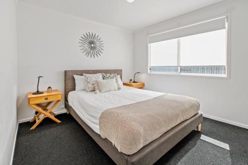 a white bedroom with a bed and a window at BIG4 Tasman Holiday Parks - Tathra Beach in Tathra