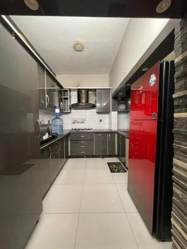 a kitchen with a red refrigerator and a tile floor at Travellers Home 2BR PORTION Gulshan Iqbal blk#7 in Karachi