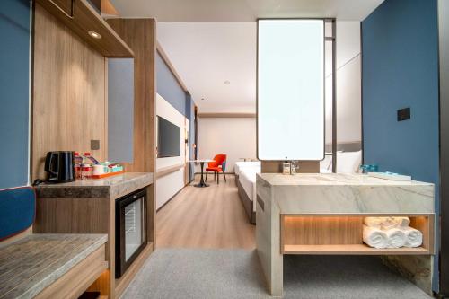 a hotel room with a bed and a bathroom at Holiday Inn Express Suzhou Shihu University Town in Suzhou