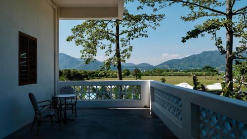 a balcony with chairs and a view of mountains at Sanhe Daoli Resort in Qingyuan