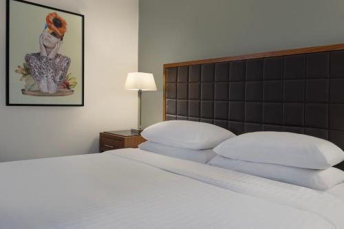 a bedroom with a white bed with a black headboard at Delta Hotels by Marriott Peterborough in Peterborough