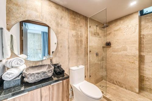 a bathroom with a toilet and a shower at Unique 1BR Swim up Cenote, and Gym in Tulum