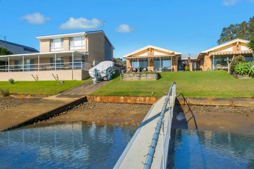 a house with a fence in the water in front of it at 29A Ballina Crescent Port Macquarie in Port Macquarie