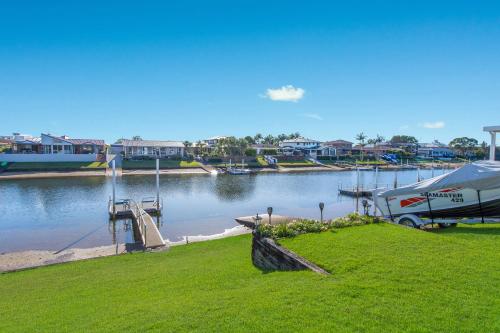 a boat is parked at a dock next to a body of water at 29A Ballina Crescent Port Macquarie in Port Macquarie
