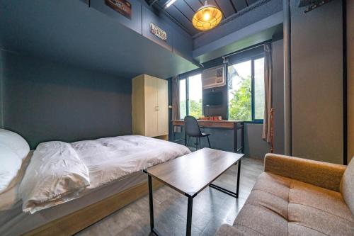 sypialnia z łóżkiem, stołem i kanapą w obiekcie 大林文旅 w mieście Dalin