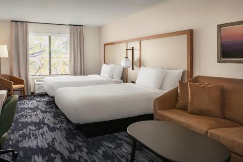 ロームにあるFairfield by Marriott Inn & Suites Rome NYのベッド2台とソファが備わるホテルルームです。