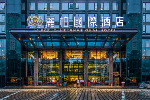 um edifício com uma placa na frente dele em La Perle International Hotel - Free shuttle between hotel and Exhibition Center during Canton Fair em Guangzhou