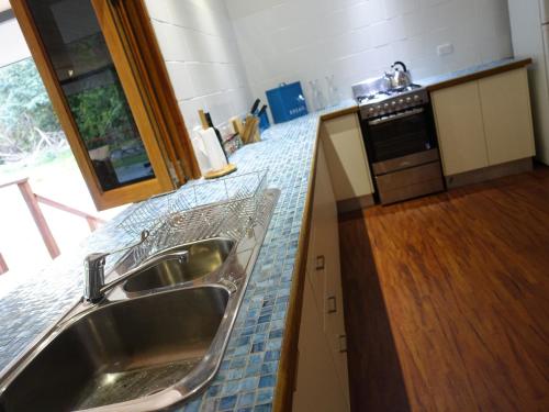 a kitchen with a sink and a counter top at Coconut Beach House in Cape Tribulation