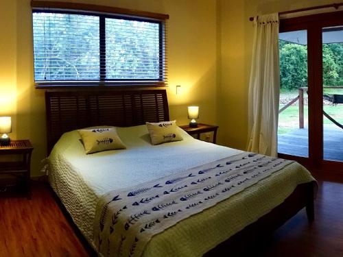 a bedroom with a bed and a large window at Coconut Beach House in Cape Tribulation