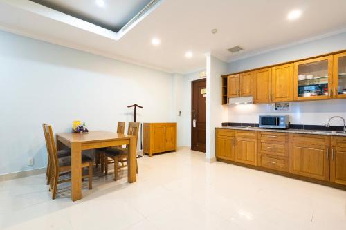 a kitchen with wooden cabinets and a wooden table at PHU MY HARBOUR HOTEL - Old Golf Phu My Hotel in Phú Mỹ