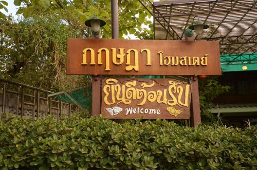 a sign for the entrance to a hotel at Baan Kitsada in Amphawa