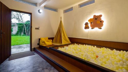 a large tub of balls in a room with a window at Sanhe Daoli Resort in Qingyuan