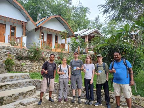 a group of people standing in front of a house at Asim Paris Guesthouse in Bukit Lawang
