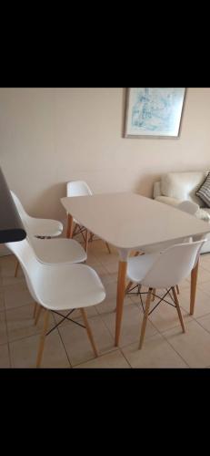 una mesa blanca y sillas en una habitación en Edificio oceanic la serena, en La Serena