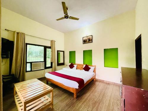 a bedroom with a bed and a ceiling fan at Karans Corbett Motel in Rāmnagar
