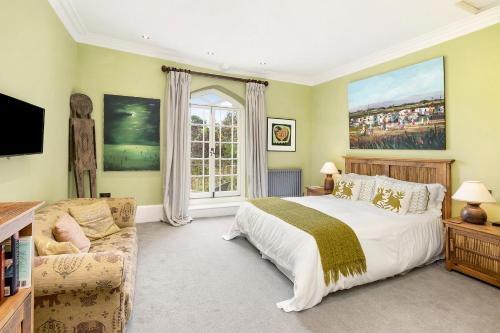 a bedroom with a bed and a large window at Colleton Hall in Rackenford