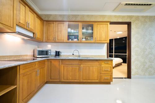 a kitchen with wooden cabinets and a sink at PHU MY HARBOUR HOTEL - Old Golf Phu My Hotel in Phú Mỹ