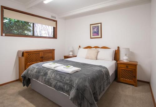 een slaapkamer met een bed met twee handdoeken erop bij Warrina - Overlooks Ovens River and five minute walk into town in Bright