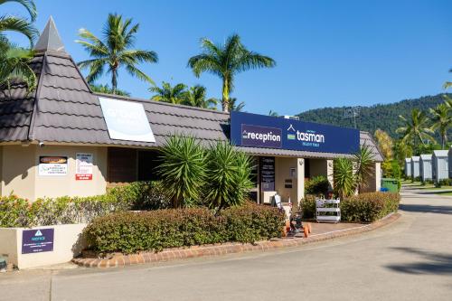 a hotel on the side of a street with palm trees at Tasman Holiday Parks - Airlie Beach in Airlie Beach