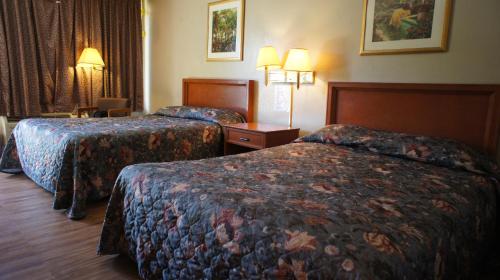 ein Hotelzimmer mit 2 Betten und 2 Lampen in der Unterkunft Executive Inn & Suites in Orange
