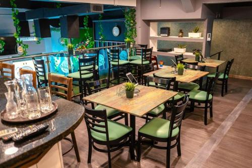 サントドミンゴにあるJardin Colonial Boutique Hotelの木製テーブルと緑の椅子が備わるレストラン
