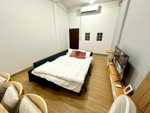 a room with a bed and a television in it at Bee House 172 only 300m to BTS Talat Phlu in Bangkok