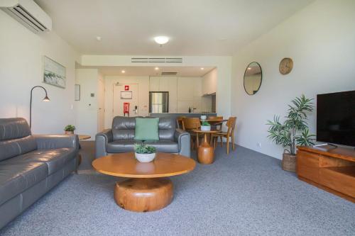 a living room with a couch and a table at 325 Harbour Lights with Garden View in Cairns