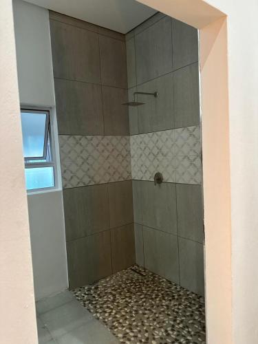 a shower with a glass door in a bathroom at Breathtaking Midlands stay at THE PROTEA CHALET 5kms from N3 in Hilton
