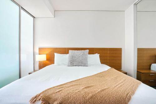 1 dormitorio con 1 cama grande con sábanas blancas en 903 Harbour Lights with Ocean Views en Cairns