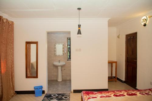 a bathroom with a sink and a mirror in a room at Gangilonga Home's in Iringa