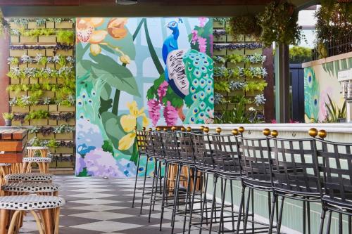 a row of chairs in a store with a flower mural at Perry Lane Hotel, a Luxury Collection Hotel, Savannah in Savannah