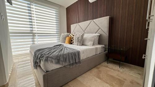 a bedroom with a bed with a headboard and a window at Departamento frente a la bahía in Acapulco