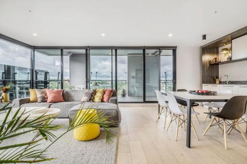 a living room with a couch and a table at VAQUAY Belladonna In Abbotsford in Melbourne