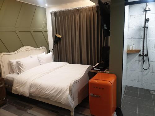 昌原市にあるHotel Giteのベッドルーム(白いベッド1台、シャワー付)