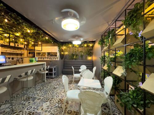 a restaurant with white tables and chairs and plants at Hotel Catedral Plaza in Santa Marta