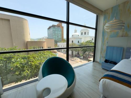 a bedroom with a bed and a large window at Hotel Catedral Plaza in Santa Marta