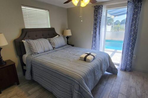 Un dormitorio con una cama con una ventana grande. en Entire home with pool & beach 5 min away!, en Englewood