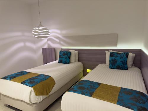 a room with two beds and a chandelier at Hotel Catedral Plaza in Santa Marta