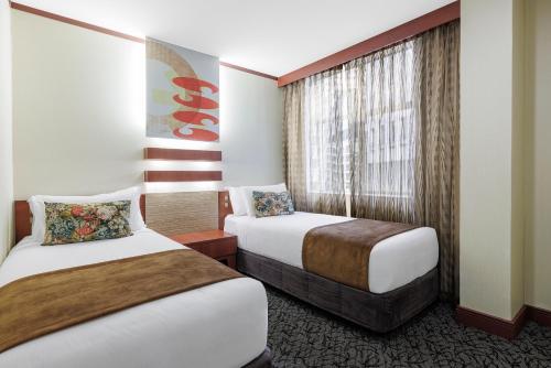 a hotel room with two beds and a window at Adina Citylife Wellington in Wellington