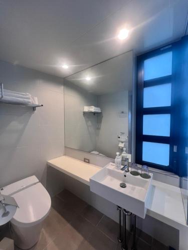ein Badezimmer mit einem WC, einem Waschbecken und einem Spiegel in der Unterkunft Shonan OVA in Yokosuka