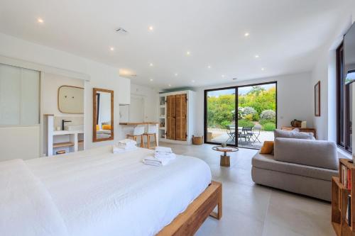 une chambre avec un grand lit blanc et un canapé dans l'établissement Studio Verveine, à Aix-en-Provence