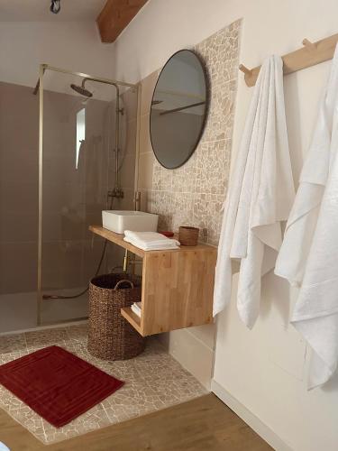 une salle de bain avec un lavabo et un miroir dans l'établissement Le Petit Mas Courriol, à Courry